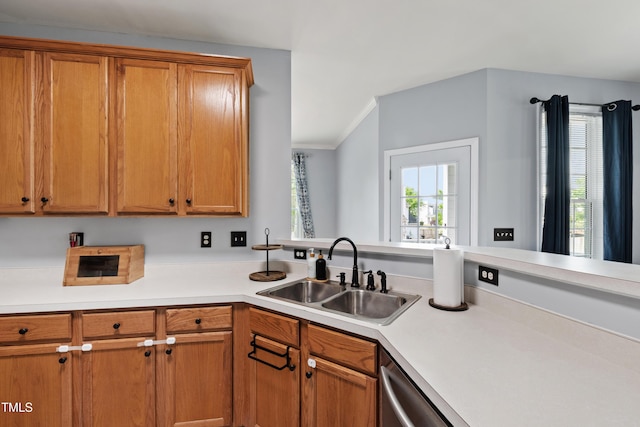 kitchen featuring a sink, light countertops, brown cabinets, and crown molding