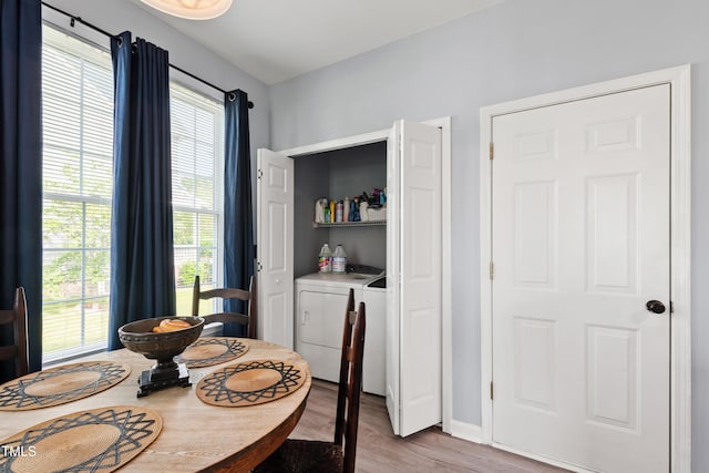 dining area featuring light wood finished floors, washing machine and dryer, plenty of natural light, and baseboards