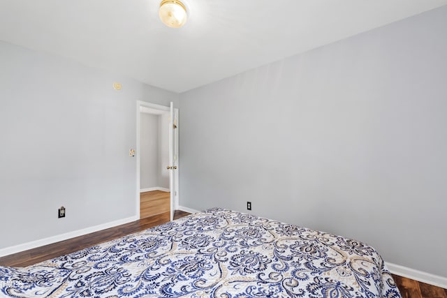 bedroom featuring baseboards and wood finished floors