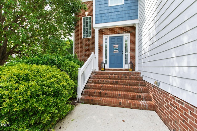 doorway to property featuring brick siding