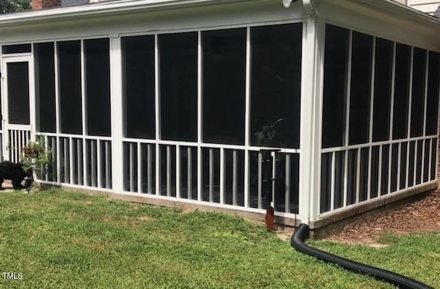 view of home's exterior featuring a sunroom and a chimney