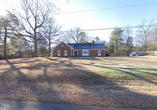 view of front of home featuring fence, a front lawn, and brick siding