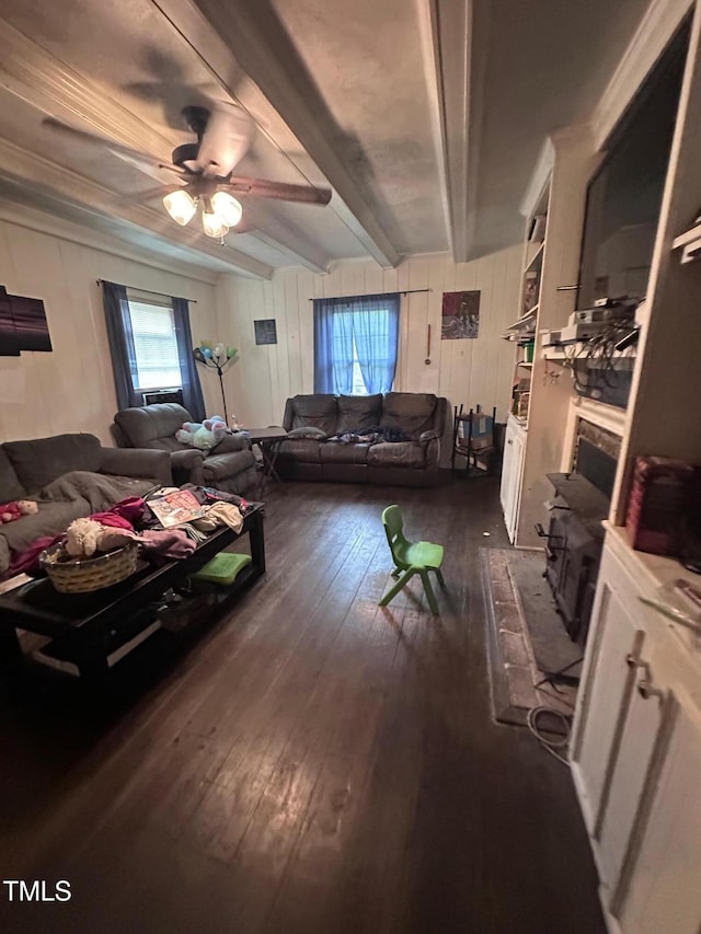 living room featuring dark wood-type flooring, plenty of natural light, ceiling fan, and beam ceiling