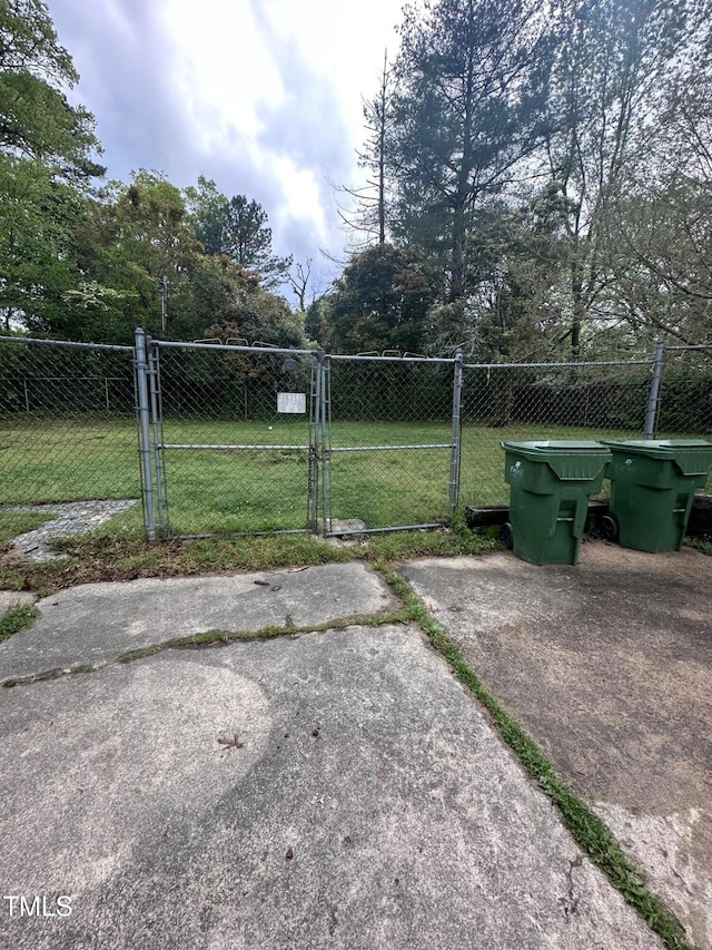 view of gate featuring fence and a yard