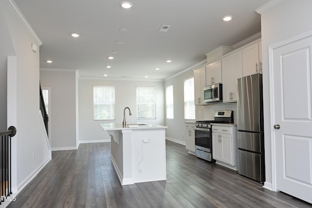2401 Laurel Valley Way, Raleigh, NC 27604 - kitchen featuring appliances with stainless steel finishes, a kitchen island with sink, ornamental molding, healthy amount of natural light, and white cabinets