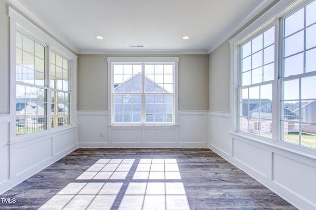 unfurnished room featuring wainscoting, ornamental molding, and wood finished floors