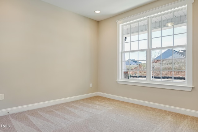 empty room with baseboards, a wealth of natural light, and carpet flooring