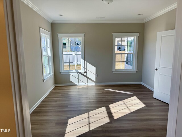 interior space with wood finished floors, crown molding, and baseboards