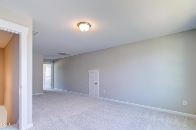 unfurnished room featuring visible vents, light colored carpet, and baseboards