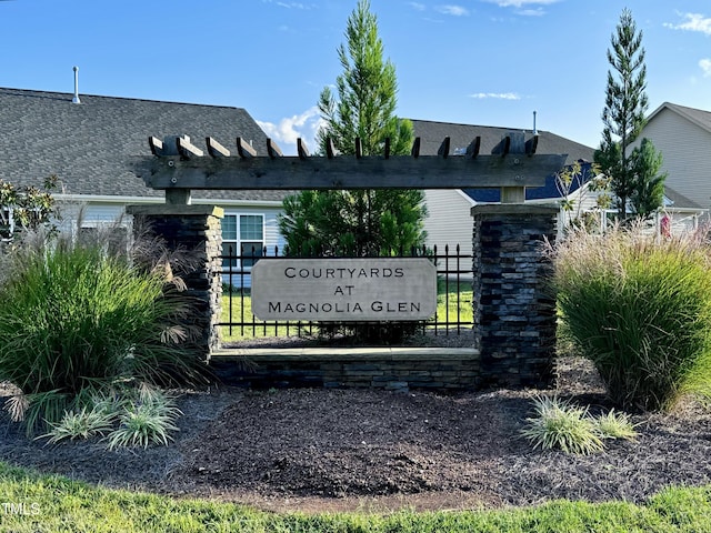 community / neighborhood sign featuring fence