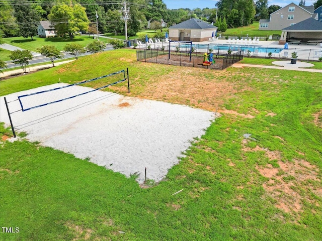 view of community with a swimming pool, a lawn, and fence