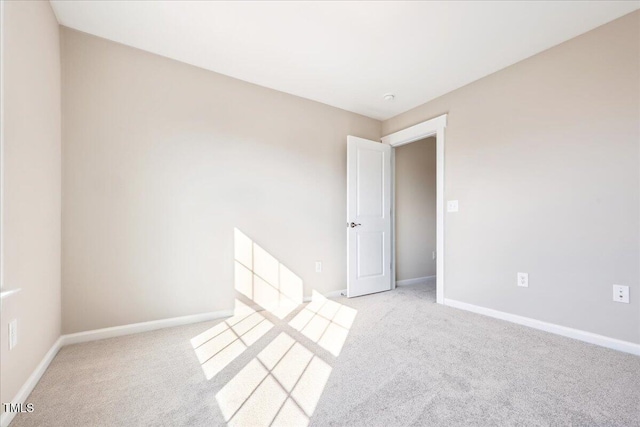 unfurnished room with baseboards and carpet