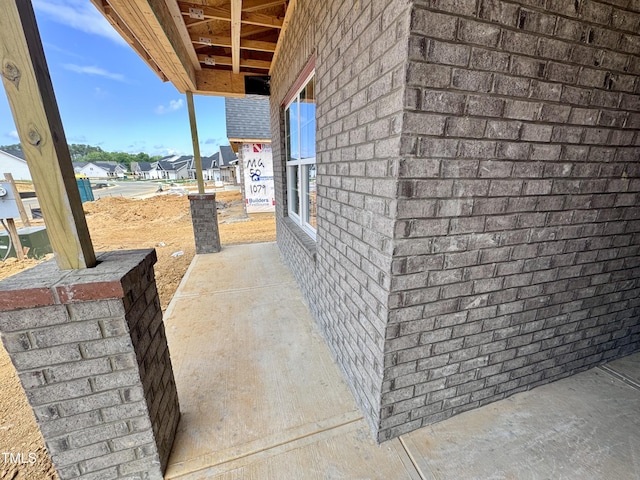 view of side of home with a residential view and brick siding