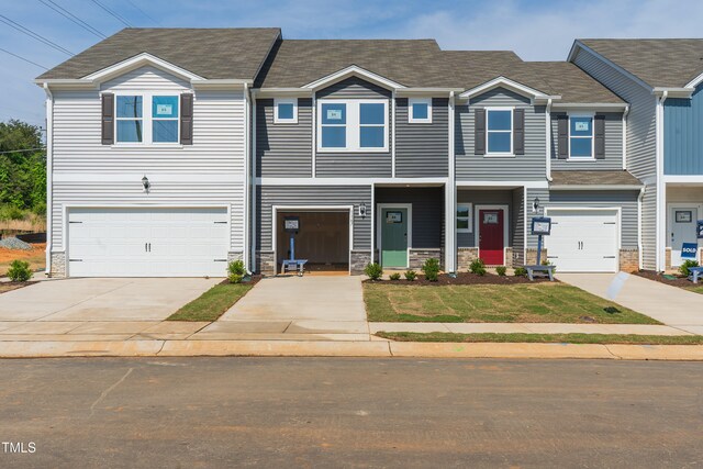 1167 Abbott St, Mebane, NC 27302 - view of front of property featuring an attached garage, concrete driveway, and stone siding