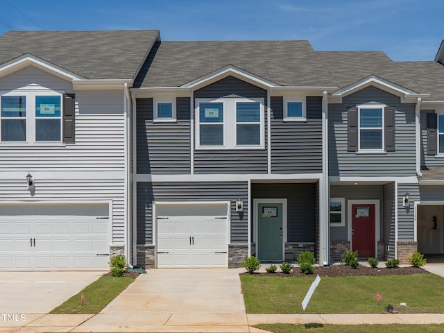 1167 Abbott St, Mebane, NC 27302 - townhome / multi-family property featuring driveway, a front yard, a shingled roof, and an attached garage