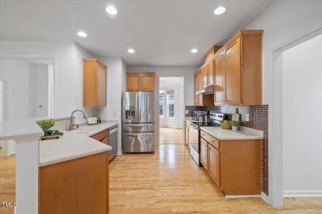 1012 Delta River Way, Knightdale, NC 27545 - kitchen with stainless steel appliances, under cabinet range hood, a sink, a peninsula, and light countertops