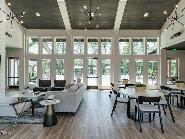 living area featuring wood finished floors, a high ceiling, and a chandelier