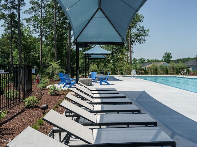 pool featuring fence, a patio, and an outdoor fire pit