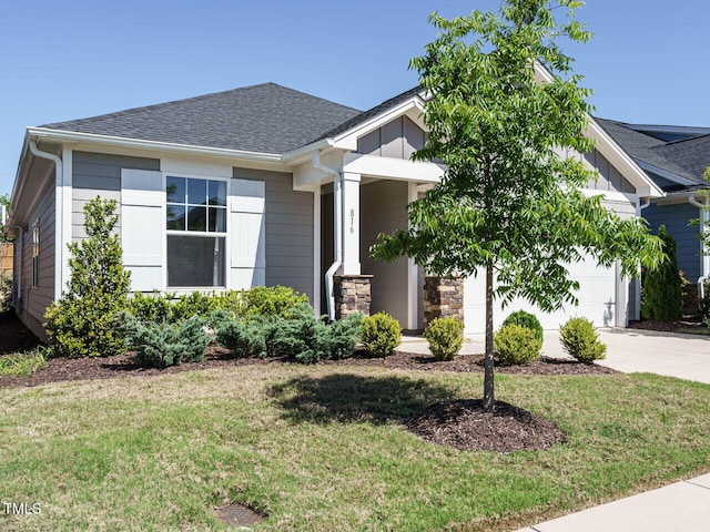 view of front facade with board and batten siding, an attached garage, concrete driveway, and a front lawn