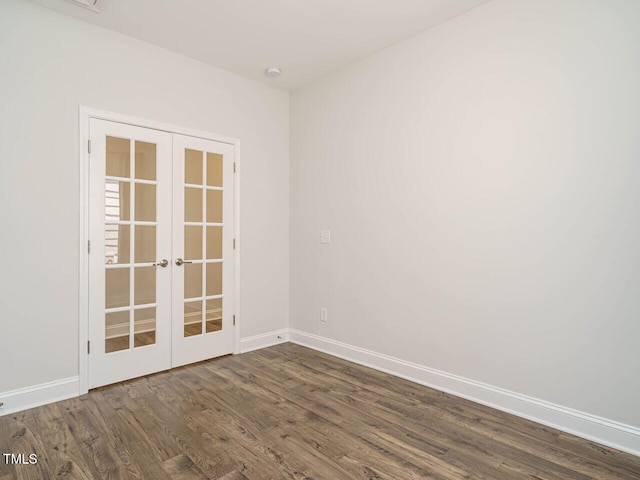 spare room with baseboards, french doors, and dark wood-type flooring