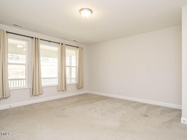 spare room featuring baseboards, carpet, and visible vents