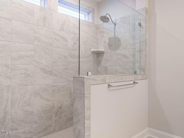 bathroom featuring baseboards and walk in shower