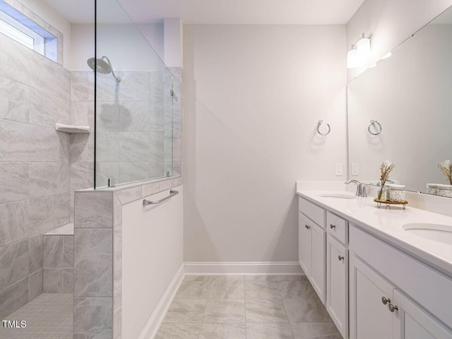 bathroom featuring double vanity, a sink, marble finish floor, and walk in shower