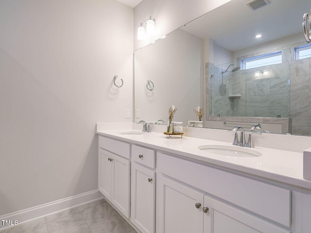 full bathroom featuring visible vents, a sink, a walk in shower, and baseboards