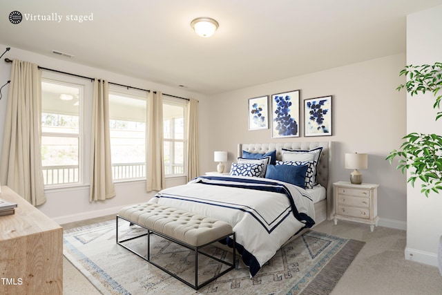 carpeted bedroom featuring baseboards, visible vents, and multiple windows