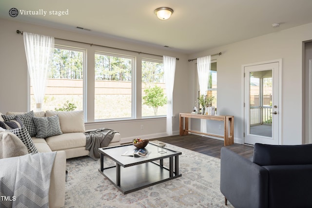 living area featuring visible vents, baseboards, and wood finished floors