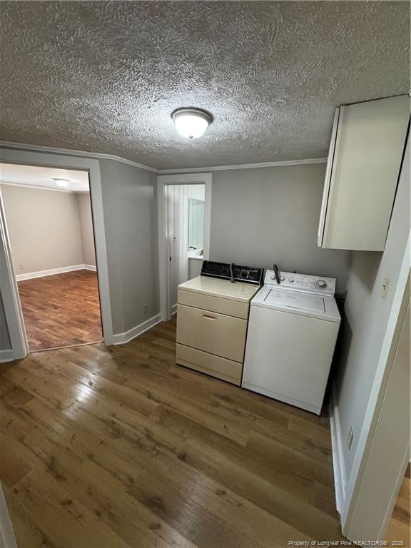 clothes washing area with baseboards, wood finished floors, separate washer and dryer, and crown molding