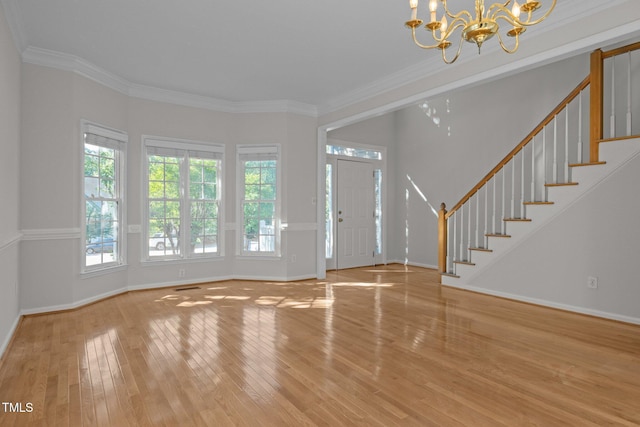 entrance foyer with crown molding, wood finished floors, baseboards, a chandelier, and stairs