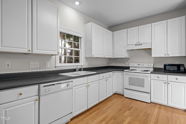 kitchen with white appliances, dark countertops, and under cabinet range hood