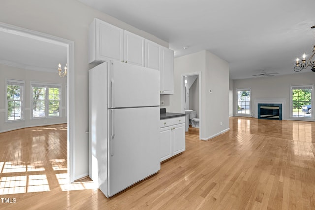 kitchen featuring white cabinets, freestanding refrigerator, light wood finished floors, and open floor plan