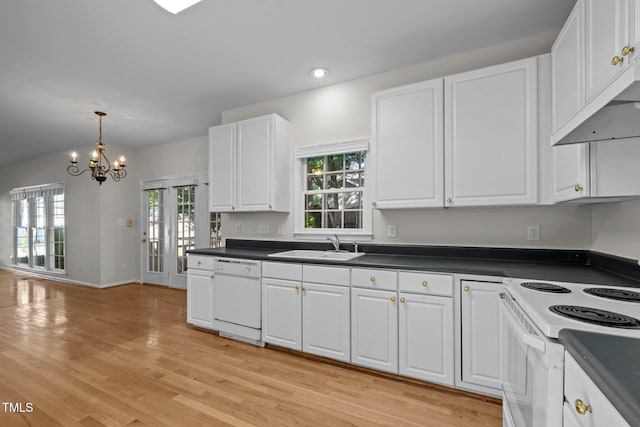 kitchen featuring dark countertops, white appliances, white cabinetry, and a notable chandelier