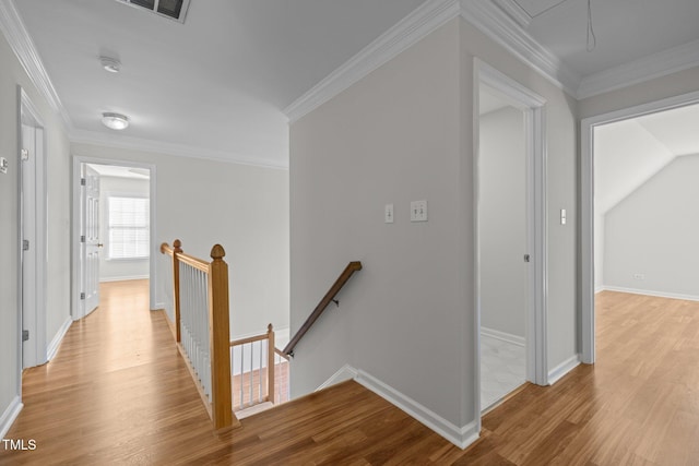 corridor with crown molding, baseboards, attic access, light wood-type flooring, and an upstairs landing