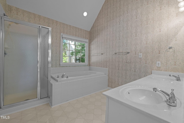 bathroom with wallpapered walls, vaulted ceiling, a shower stall, and a sink