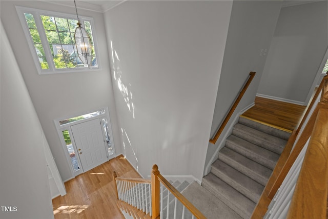 entrance foyer featuring crown molding, baseboards, stairs, and light wood finished floors