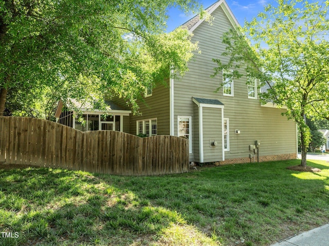 rear view of house with fence and a yard