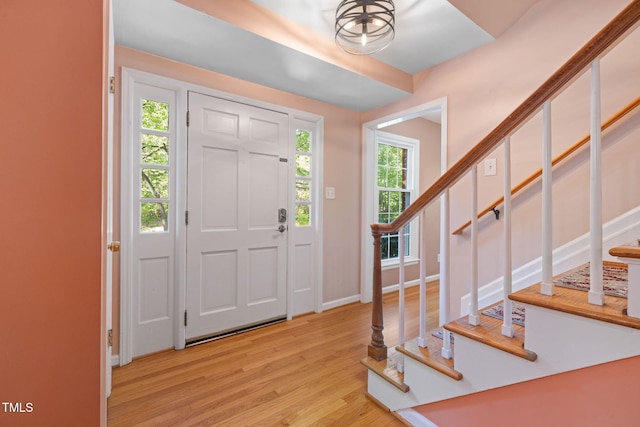 entryway featuring baseboards, stairs, and wood finished floors