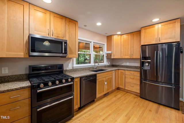 kitchen featuring stainless steel appliances, recessed lighting, a sink, and light wood finished floors