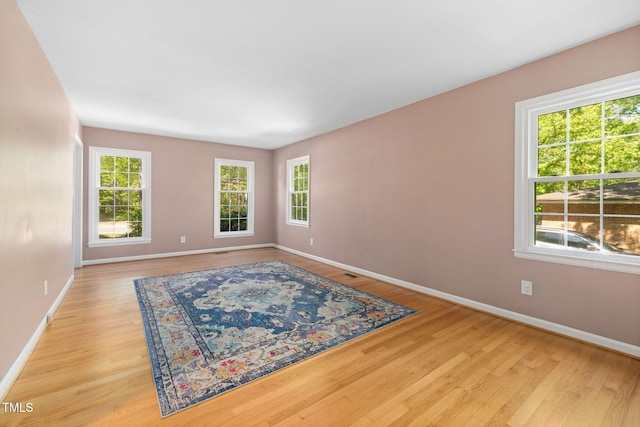 unfurnished room with baseboards and wood finished floors
