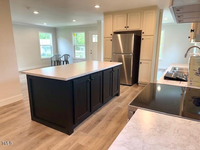 kitchen with dark cabinets, exhaust hood, freestanding refrigerator, electric range, and light countertops