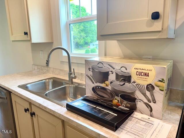 interior details featuring dishwasher, light countertops, and a sink