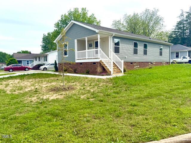 single story home with a front yard, crawl space, and covered porch