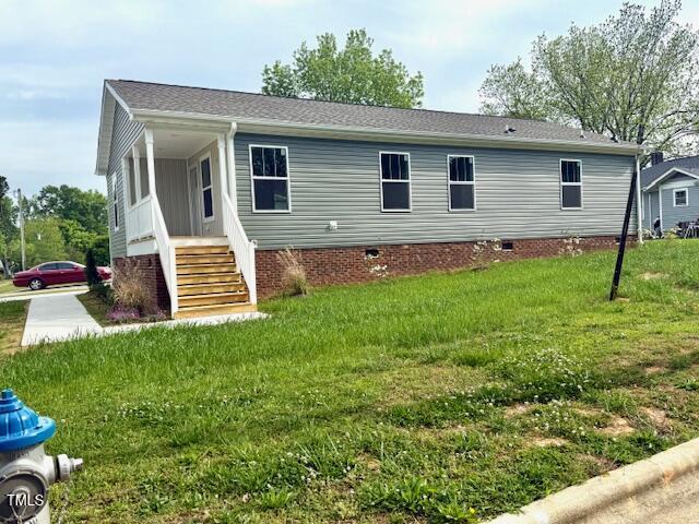 back of house with a lawn and crawl space