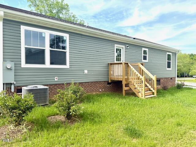 back of house with a yard, crawl space, and central AC