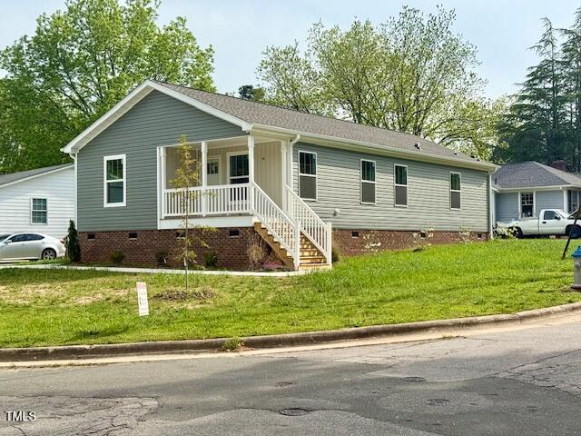 ranch-style house featuring covered porch, a front yard, and crawl space