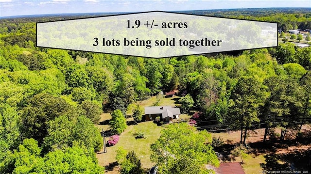 bird's eye view with a wooded view