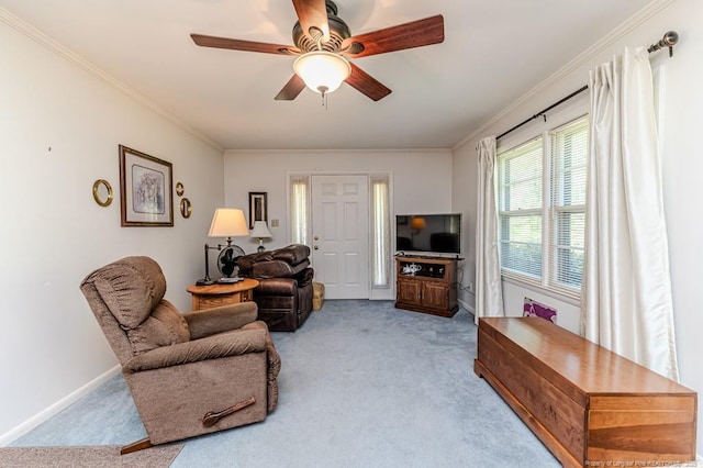 carpeted living room featuring baseboards, ceiling fan, and crown molding